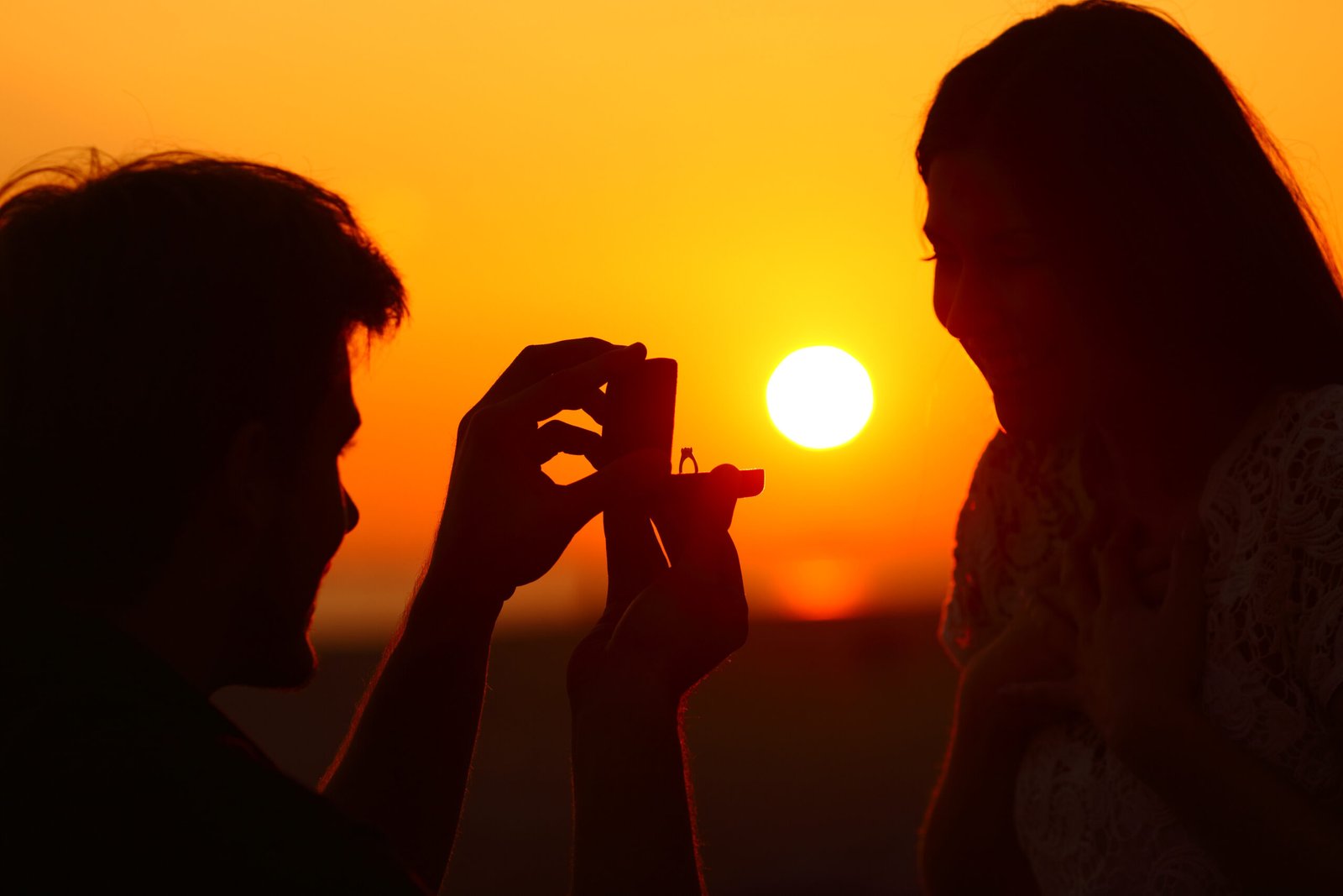 Home marriage proposal at sunset with sun in background